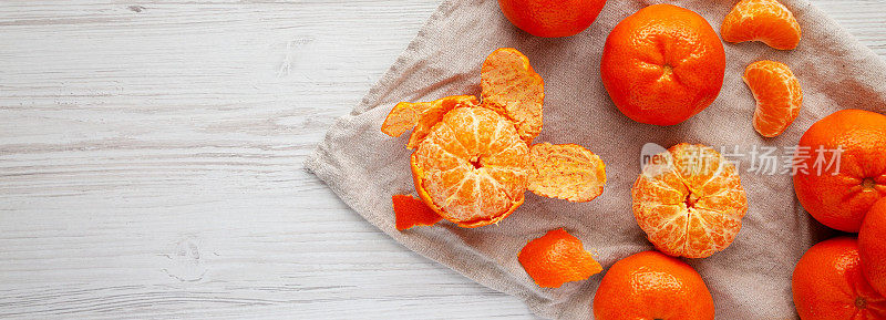Raw Organic Mandarin Oranges on a white wooden background, top view. Flat lay, overhead, from above. Space for text.